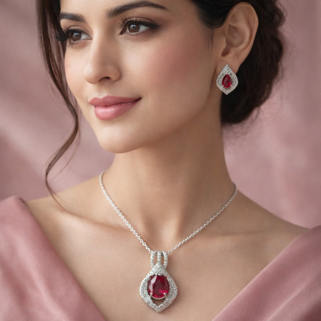Woman wearing a red gemstone necklace and earrings against a pink background